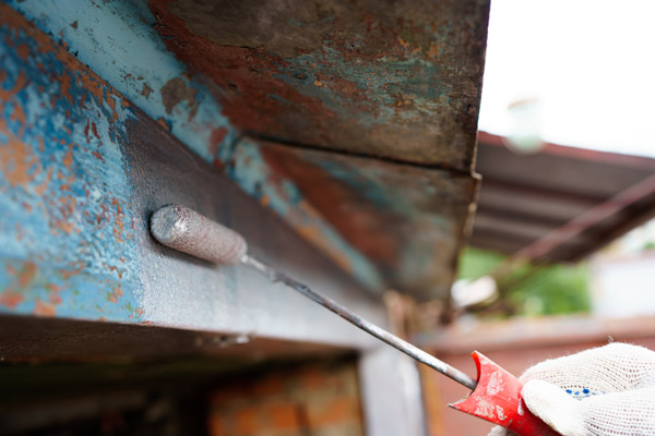 a man repairing his rusty garage door